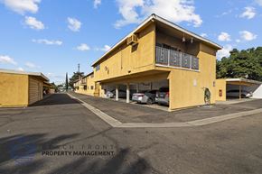 Downey apartment for rent - a yellow building with cars parked in front of it on a street
