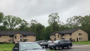 Island Lake apartment for rent - a parking lot filled with cars in front of two buildings