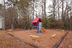 Jonesboro apartment for rent - a playground with a red swing set and benches
