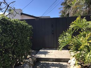 San Diego apartment for rent - a black fence in a backyard with a pathway and plants