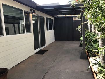 San Diego apartment for rent - the side entrance to the house with a concrete walkway and glass doors