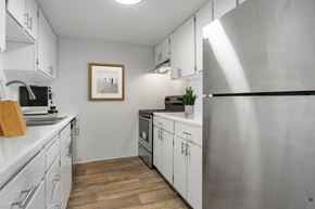 Burien apartment for rent - A modern kitchen with stainless steel appliances and wooden floors.