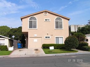 San Diego apartment for rent - A beige house with a blue trash can in front.