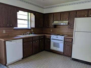Stillwater house for rent - A kitchen with brown cabinets and white appliances.