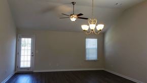 Harlem apartment for rent - an empty living room with a ceiling fan and a door