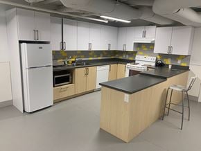 Vancouver apartment for rent - a kitchen with white cabinets and counters and a refrigerator