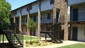 Stillwater apartment for rent - an exterior view of an apartment building with stairs and trees