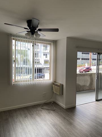 West Hollywood apartment for rent - a living room with a ceiling fan and a window