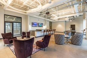 Chicago apartment for rent - a lounge area with chairs and a bar and a tv