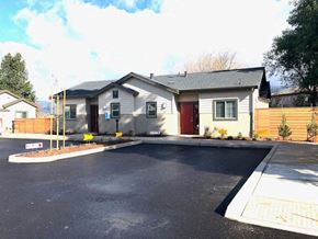 Gilroy apartment for rent - a white house with a driveway and a parking lot