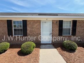 Wilson apartment for rent - A building with a white door and windows with black shutters.