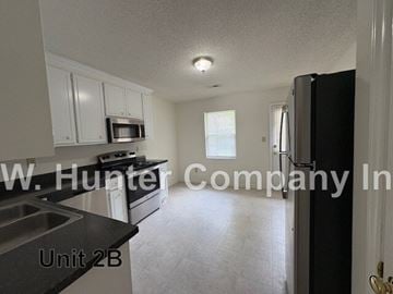Wilson apartment for rent - A kitchen with white cabinets and a black counter top.