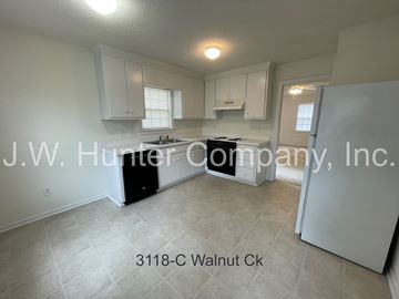 Wilson apartment for rent - A kitchen with white cabinets and a black stove top oven.