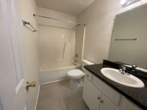 Wilson apartment for rent - A bathroom with a toilet, sink, and shower.