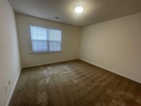 Wilson apartment for rent - A room with a carpeted floor and a window with blinds.