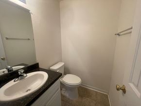 Wilson apartment for rent - A bathroom with a toilet, sink, and a door.