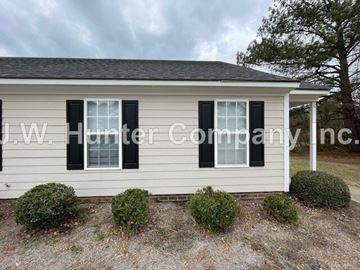 Wilson apartment for rent - A house with a sign that reads "J.W. Hunter Company Inc." in front of it.