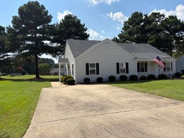 Wilson apartment for rent - A white house with a flag on the front porch.