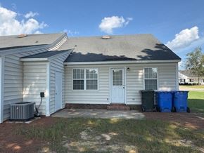 Wilson apartment for rent - A house with a grey roof and a white door is shown.