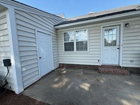 Wilson apartment for rent - A small white house with a grey roof and a white door.