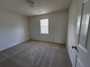 Wilson apartment for rent - A room with a carpeted floor and a door on the right side.