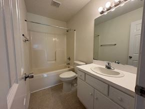 Wilson apartment for rent - A white bathroom with a toilet, sink, and shower.