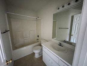 Wilson apartment for rent - A white bathroom with a toilet, sink, and bathtub.