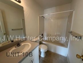 Wilson apartment for rent - A bathroom with a toilet, sink, and bathtub.