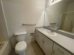 Wilson apartment for rent - A white toilet sits next to a sink in a small bathroom.