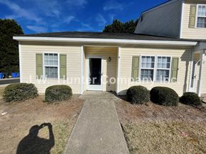 Wilson apartment for rent - A house with a white door and green shutters is for sale.
