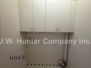 Wilson apartment for rent - A white tiled bathroom with a white cabinet and a white pipe.