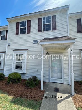 Wilson apartment for rent - A white house with a brown roof and a sign that reads "JW Hunter Company, Inc.".