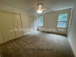 Wilson apartment for rent - A room with a carpet floor and a ceiling fan.