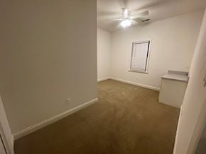 Wilson apartment for rent - A room with a carpeted floor and a ceiling fan.
