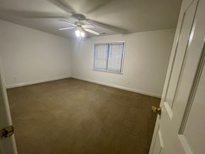 Wilson apartment for rent - A room with a ceiling fan and a window with blinds.