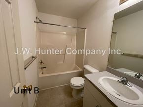 Wilson apartment for rent - A bathroom with a toilet, sink, and bathtub.