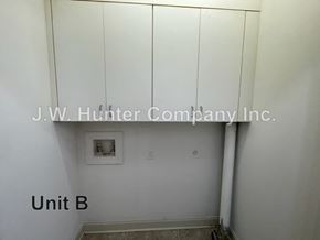 Wilson apartment for rent - A white wall with a pipe and a picture frame.