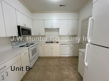 Wilson apartment for rent - A kitchen with white cabinets and appliances in a small room.