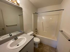 Wilson apartment for rent - A white bathroom with a toilet, sink, and shower.