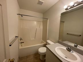 Wilson apartment for rent - A bathroom with a toilet, sink, and bathtub.