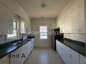 Wilson apartment for rent - A kitchen with white cabinets and black countertops.
