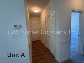 Wilson apartment for rent - A hallway with a door on the right and a wall-mounted thermostat on the left.