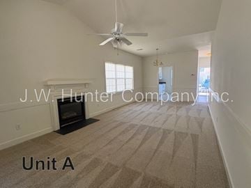 Wilson apartment for rent - A spacious living room with a carpet floor and a ceiling fan.