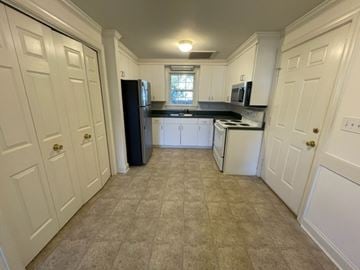 Wilson apartment for rent - A kitchen with white cabinets and a black refrigerator.