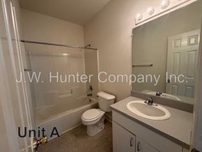 Wilson apartment for rent - A bathroom with a toilet, sink, and bathtub.