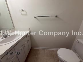 Wilson apartment for rent - A bathroom with a toilet, sink, and towel bar.