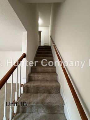 Wilson apartment for rent - A staircase with a carpeted runner and wooden handrails.