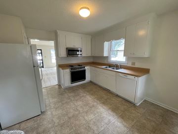 Wilson apartment for rent - A kitchen with white cabinets and a tiled floor.