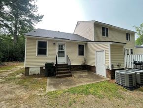 Wilson apartment for rent - A house with a white door and windows is surrounded by trees.