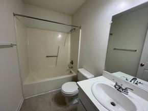 Wilson apartment for rent - A white bathroom with a toilet, sink, and bathtub.